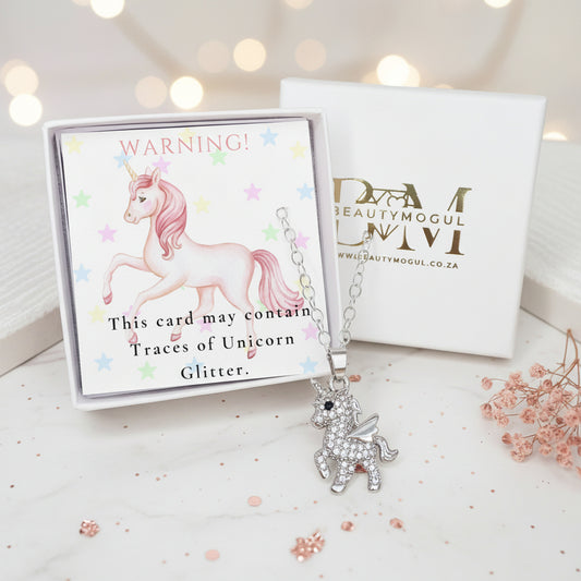 ccovered in clear rhinestones, displayed in front of its white gift box. The box features a colorful warning label with a pink unicorn and text about 'Unicorn Glitter.