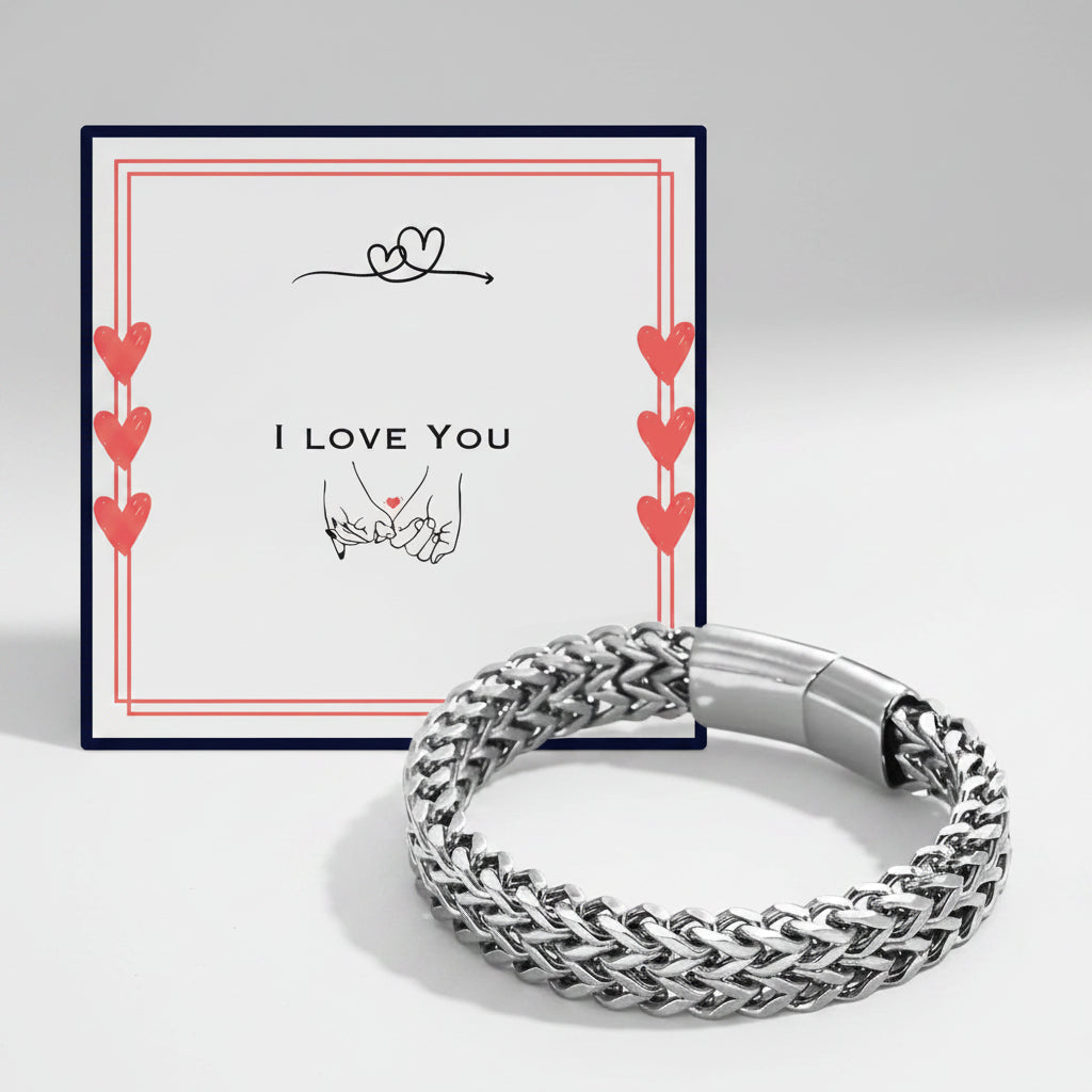 A silver braided chain bracelet displayed in front of its white gift box. The box features a navy blue border, red hearts, and the text 'I LOVE YOU' with a hand-drawn heart and hands graphic.