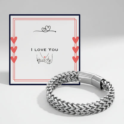A silver braided chain bracelet displayed in front of its white gift box. The box features a navy blue border, red hearts, and the text 'I LOVE YOU' with a hand-drawn heart and hands graphic.