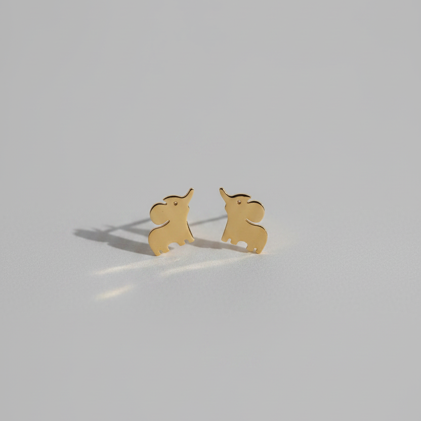 A pair of small gold elephant stud earrings on a plain light gray background.