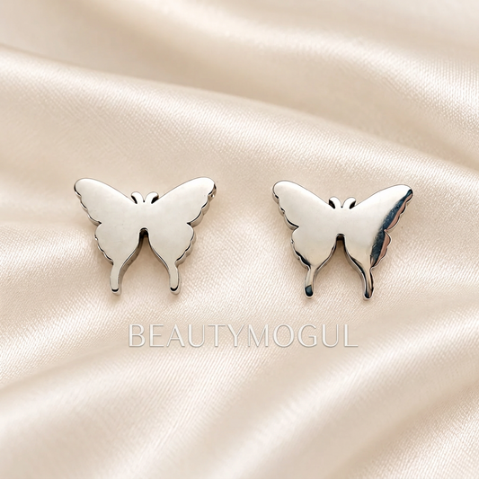 Pair of silver-tone butterfly stud earrings displayed on ivory satin.