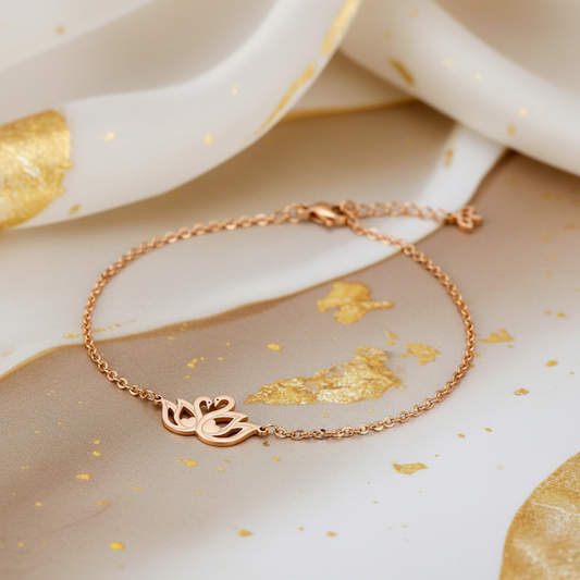 A delicate beautymogul rose gold chain bracelet with a swan cutout charm, displayed on a styled background of white and gold marbled paper.
